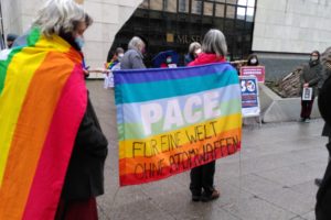 Zwei Frauen halten Pace-Fahne auf der steht: Für eine Welt ohne Atomwaffen